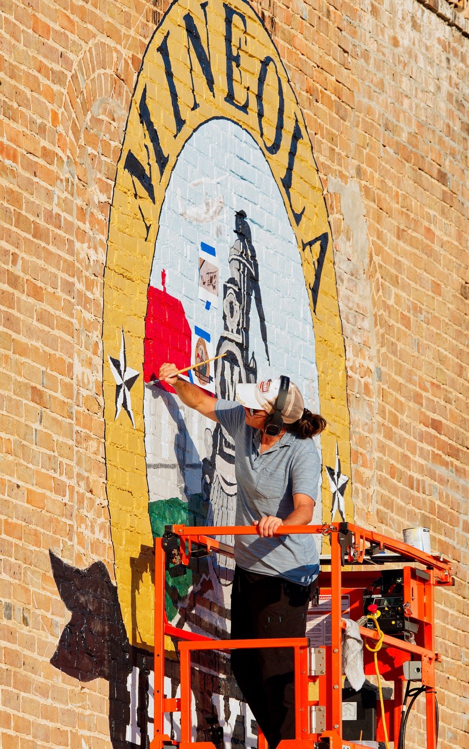 Erica Fry is completing the 150th anniversary (sesquicentennial) logo on S. Johnson St. for the city of Mineola in anticipation of a year-long series of events surrounding the city’s founding in May 1873. [look at logo progress]
